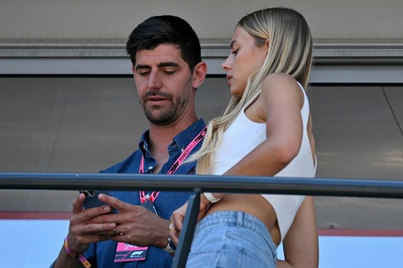 Belgian goalkeeper Thibaut Courtois (L) and wife Mishel Gerzig look at a mobile phone on a balcony ahead of the Formula One Monaco Grand Prix at the Circuit de Monaco, on May 25, 2025.  Andrej ISAKOVIC / AFP