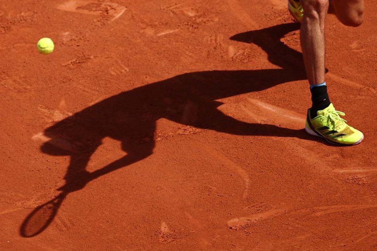 The shadow of Germany's Alexander Zverev playing a backhand to Italy's Flavio Cobolli is casted on the clay during their men's singles match on day 7 of the French Open tennis tournament on Court Philippe-Chatrier at the Roland-Garros Complex in Paris on May 31, 2025.  Anne-Christine POUJOULAT / AFP