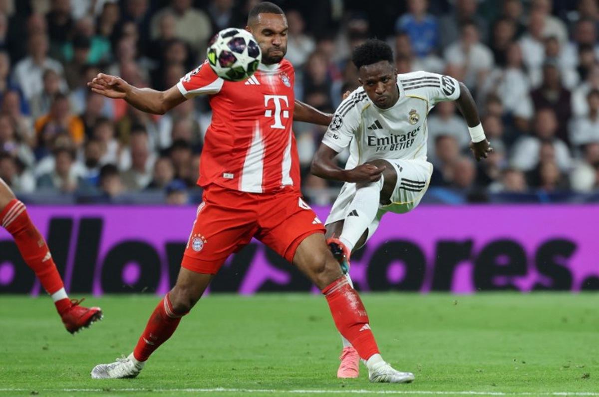 Real Madrid's Brazilian forward #07 Vinicius Junior (R) kicks past Bayern Munich's German defender #04 Jonathan Tah during the UEFA Champions League quarter final first leg football match between Real Madrid CF and FC Bayern Munich at Santiago Bernabeu Stadium in Madrid on April 7, 2026.  Thomas COEX / AFP