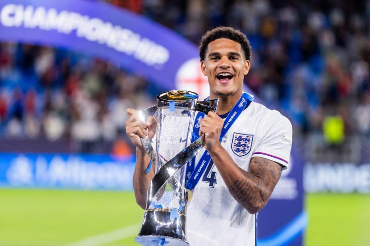 England's defender #04 Jarell Quansah holds the trophy as he celebrates after his team won the UEFA U21 European Championship final football match between England and Germany in Bratislava, Slovakia on June 28, 2025. England successfully defended their Under-21 European Championship title in a 3-2 extra-time victory over Germany in the final. Branislav Racko / AFP