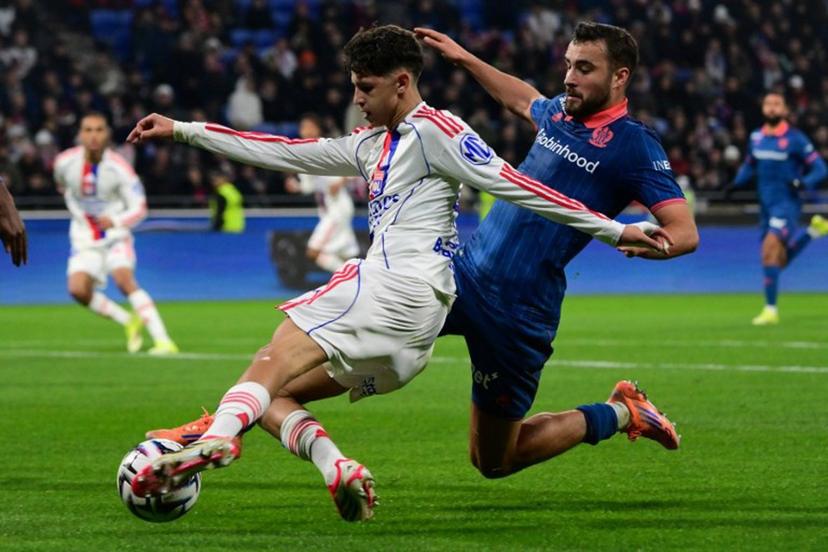 Lyon's French midfielder #44 Khalis Merah (L) and Nice's Belgian midfielder #24 Charles Vanhoutte (R) fight for the ball during the French L1 football match between Olympique Lyonnais (OL) and OGC Nice at the Groupama Stadium in Decines-Charpieu, central-eastern France, on February 15, 2026.  OLIVIER CHASSIGNOLE / AFP