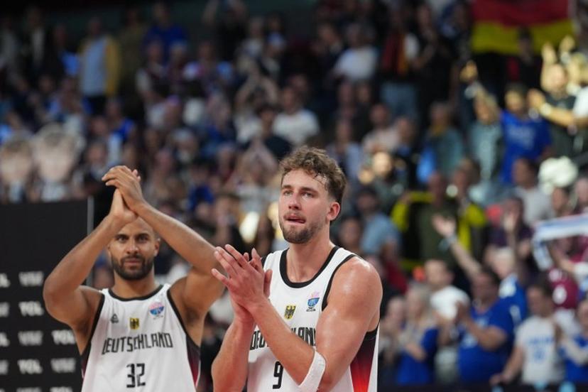 Germany's power forward #32 Johannes Thiemann (L) and Germany's guard #09 Franz Wagner celebrate after the end of the FIBA EuroBasket 2025 semi-final basketball match between Germany and Finland in Riga, Latvia, on September 12, 2025.  Gints Ivuskans / AFP