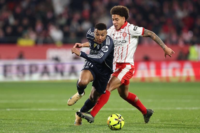 Real Madrid's French forward #10 Kylian Mbappe (L) fights for the ball with Girona's Belgian defender #20 Axel Witsel during the Spanish league football match between Girona FC and Real Madrid CF at Montilivi Stadium in Girona on November 30, 2025.  Josep LAGO / AFP