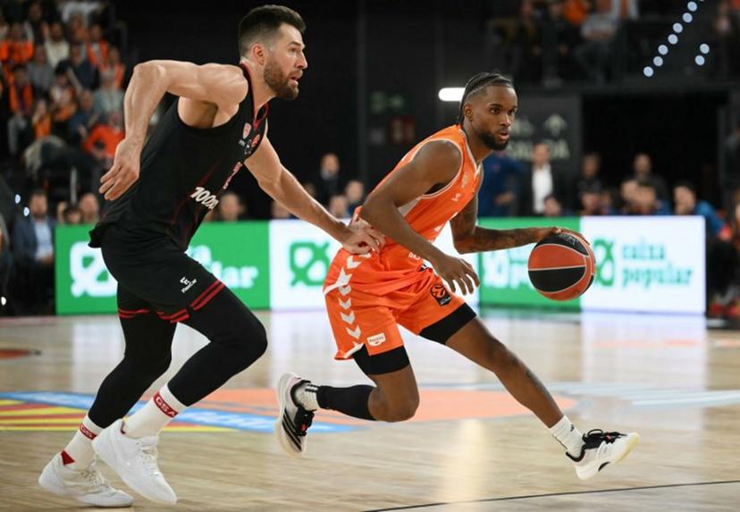 Valencia's Dominican Republic guard #8 Juan Montero drives the ball against Olympiacos Piraeus' US forward #25 Alec Peters during the Euroleague basketball match between Valencia Basket and Olympiacos at the Roig arena in Valencia on March 24, 2026.   JOSE JORDAN / AFP