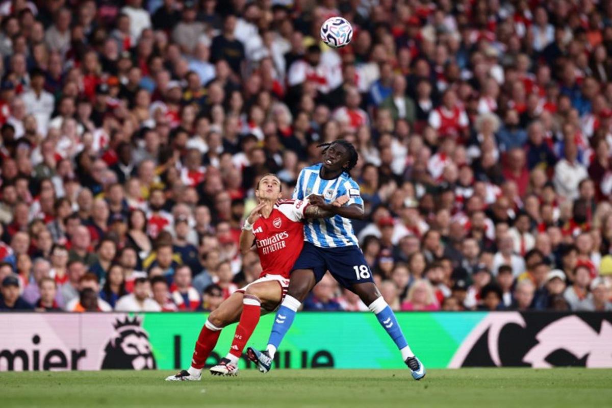 Arsenal's Italian defender #33 Riccardo Calafiori battles for the ball with Coventry City's French midfielder #18 Loum Tchaouna during the English Premier League football match between Arsenal and Coventry City at the Emirates Stadium in London on August 21, 2026.   Henry NICHOLLS / AFP