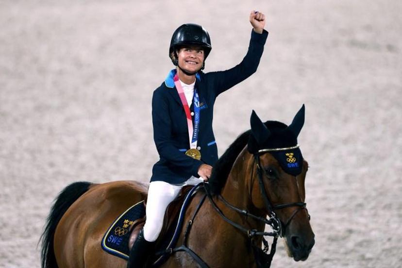 (L-R) Gold medalist, Sweden Malin Baryard-Johnsson parades with Indiana after the medal ceremony of the equestrian's jumping team during the Tokyo 2020 Olympic Games at the Equestrian Park in Tokyo on August 7, 2021.  Behrouz MEHRI / AFP