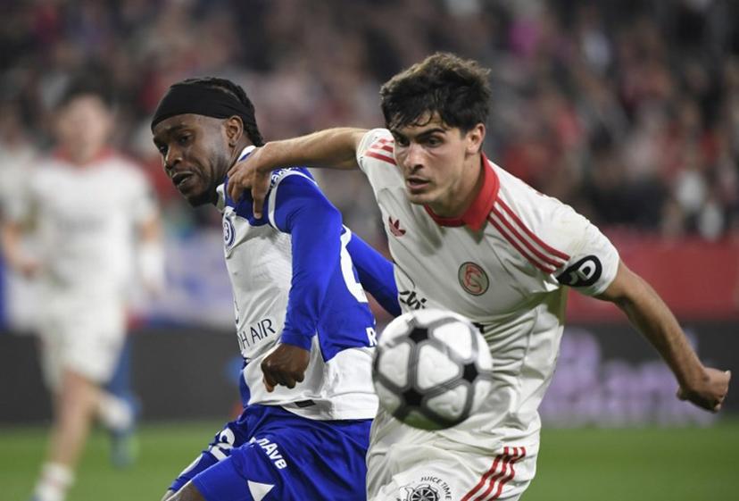 Atletico Madrid's English forward #22 Ademola Lookman fights for the ball with Sevilla's Spanish defender #16 Juanlu Sanchez during the Spanish league football match between Sevilla FC and Club Atletico de Madrid at the Ramon Sanchez Pizjuan stadium in Seville on April 11 , 2026.  CRISTINA QUICLER / AFP