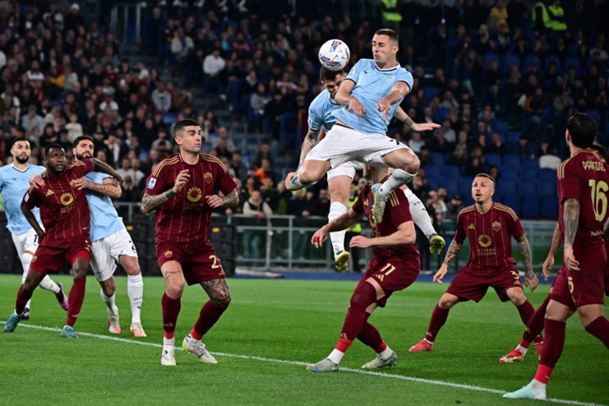 Lazio's Montenegrin defender #77 Adam Marusic jumps for the ball during the Italian Serie A football match between Lazio and Roma at the Olympic Stadium in Rome on April 13, 2025.  Tiziana FABI / AFP