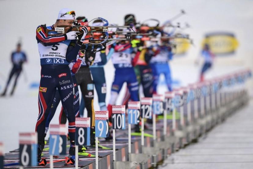 Norway's Vetle Sjaastad Christiansen (L) fires his rifle during the men's 15km mass start event of the IBU Biathlon World Cup, in Le Grand Bornand, near Annecy, southeastern France, on December 21, 2025.  Olivier CHASSIGNOLE / AFP