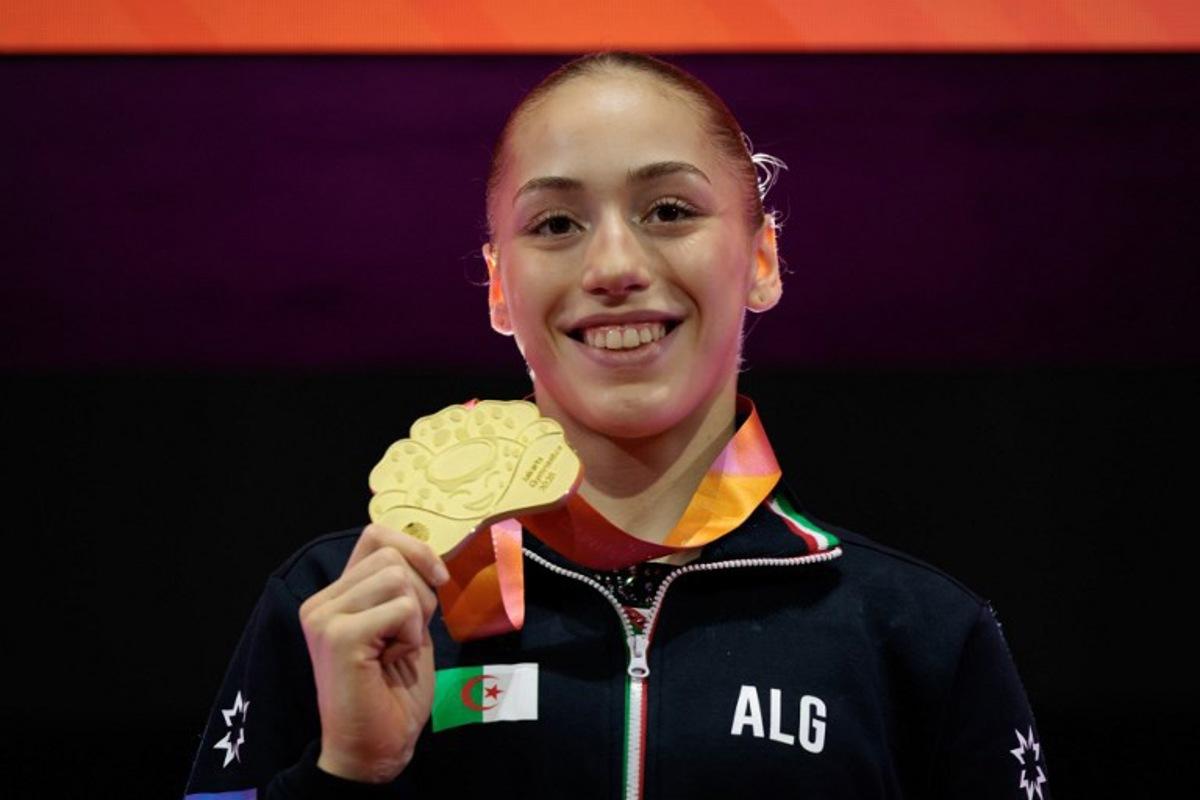 First-placed Algeria's Kaylia Nemour with the gold medal poses during the victory ceremony for the women's uneven bars final at the 53rd FIG Artistic Gymnastics World Championships in Jakarta on October 24, 2025.   Yasuyoshi CHIBA / AFP