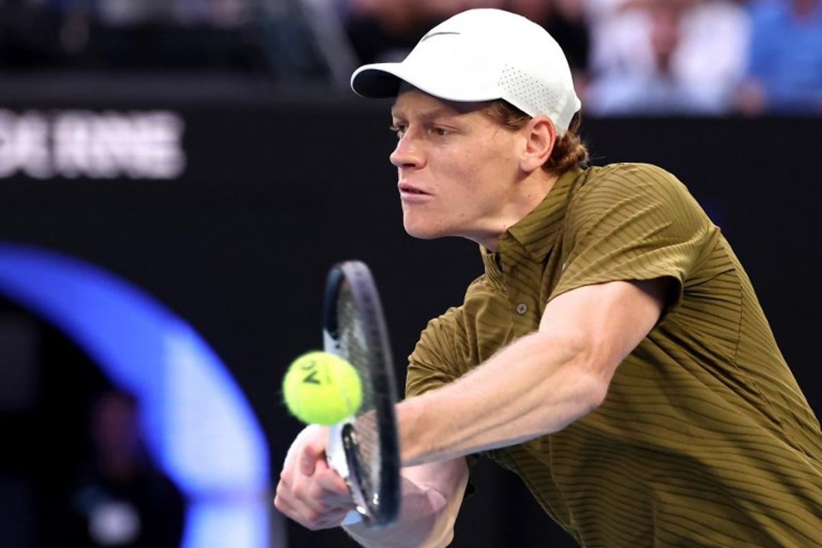 Italy's Jannik Sinner hits a return to USA's Ben Shelton during their men's singles quarter-final match on day eleven of the Australian Open tennis tournament in Melbourne on January 28, 2026.  DAVID GRAY / AFP