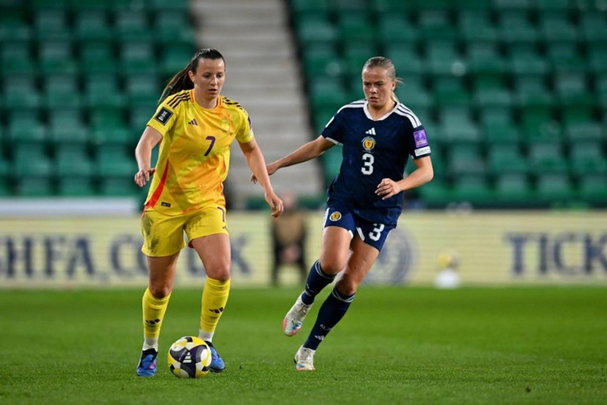 Belgium's forward #07 Hannah Eurlings runs with the ball from Scotland's Defender #03 Amy Muir during the Women's FIFA world cup league B, group 4, qualifier football match between Scotland and Belgium at Easter Road, in Edinburgh, Scotland, on April 14, 2026.  ANDY BUCHANAN / AFP
