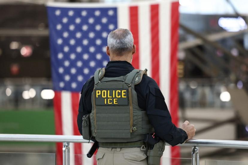 A US Immigrations and Customs Enforcement (ICE) stands watch at a security checkpoint at John F. Kennedy International Airport in New York, on March 23, 2026. Immigration agents will be deployed in US airports beginning Monday, aiming to alleviate soaring congestion at security screenings amid a weeks-long budget standoff over President Donald Trump's mass deportation drive, officials said. CHARLY TRIBALLEAU / AFP