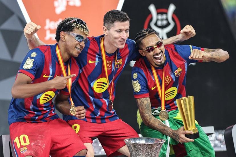 Barcelona's Spanish forward #10 Lamine Yamal, Polish forward #09 Robert Lewandowski and Brazilian forward #11 Raphinha celebrate after winning the Spanish Super Cup final football match between FC Barcelona and Real Madrid at the King Abdullah Stadium in Jeddah on January 11, 2026.  Fadel SENNA / AFP