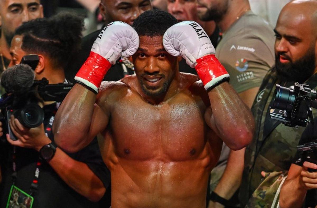 British boxer Anthony Joshua celebrates after defeating US boxer and influencer Jake Paul (off frame) in a non-title heavyweight bout at the Kaseya Center in Miami, Florida, on December 19, 2025.  Giorgio VIERA / AFP