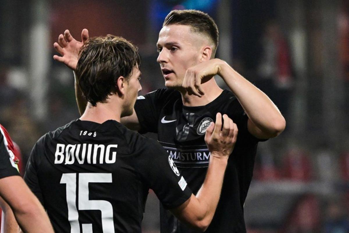 Sturm Graz's Danish forward #15 William Boving and Sturm Graz's Belgian defender #24 Dimitri Lavalee celebrate after Brest's scored an own goal during the UEFA Champions League 1st round day 1 football match between Stade Brestois 29 (Brest) and Sturm Graz, at the Roudourou Stadium in Guingamp, western France, on September 19, 2024.  Damien MEYER / AFP
