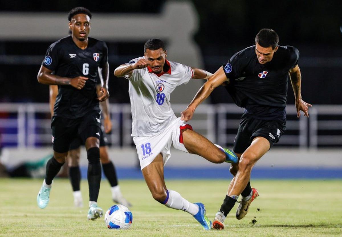 Haiti's forward #18 Wilson Isidor and Dominican Republic's defender #05 Noah Dollenmayer fight for the ball during the Concacaf Nations League Cup football match between Dominican Republic and Haiti at the Felix Sanchez Olympic Stadium in Santo Domingo on October 1, 2026.  Nelson PULIDO / AFP