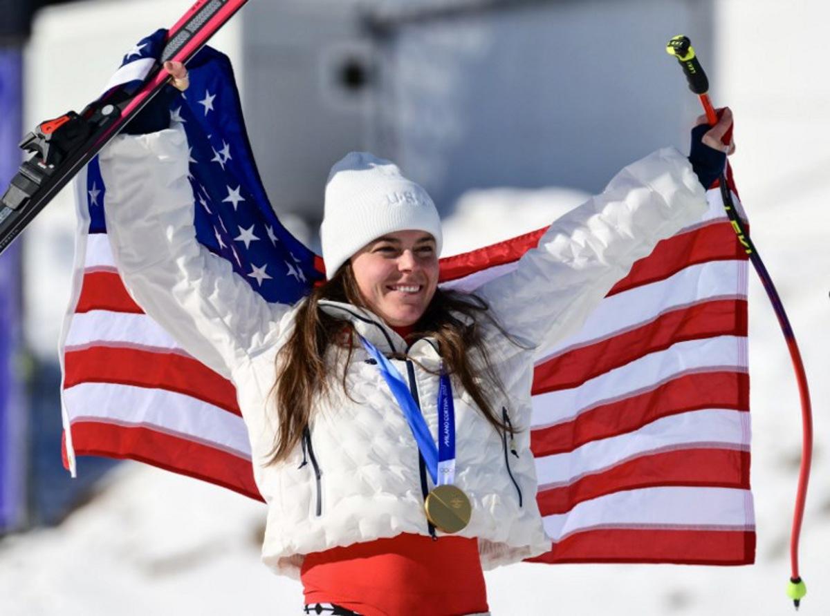 US' Breezy Johnson celebrates with her gold medal on the podium of the women's downhill event during the Milano Cortina 2026 Winter Olympic Games at the Tofane Alpine Skiing Centre in Cortina d'Ampezzo on February 8, 2026.  Stefano RELLANDINI / AFP