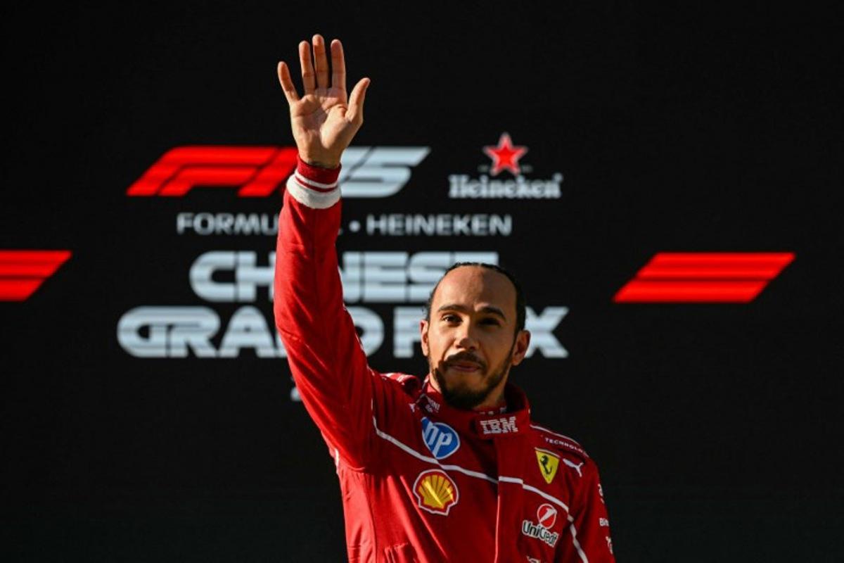 Ferrari's British driver Lewis Hamilton waves as he celebrates taking pole position after the sprint qualifying session of the Formula One Chinese Grand Prix at the Shanghai International Circuit in Shanghai on March 21, 2025.  GREG BAKER / AFP