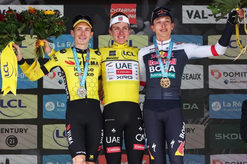 Second placed for the overall race Team Visma - Lease a Bike's Danish rider Jonas Vingegaard (L), first placed UAE Team Emirates XRG's Slovenian rider Tadej Pogačar wearing the overall leader's yellow jersey and third placed Red Bull - BORA - hansgrohe's German rider Florian Lipowitz celebrate on the podium of the 8th and final stage of the 77th edition of the Criterium du Dauphine cycling race, 133,3 km between Val-d'Arc and Val-Cenis - Plateau du Mont Cenis, on June 15, 2025.  Anne-Christine POUJOULAT / AFP