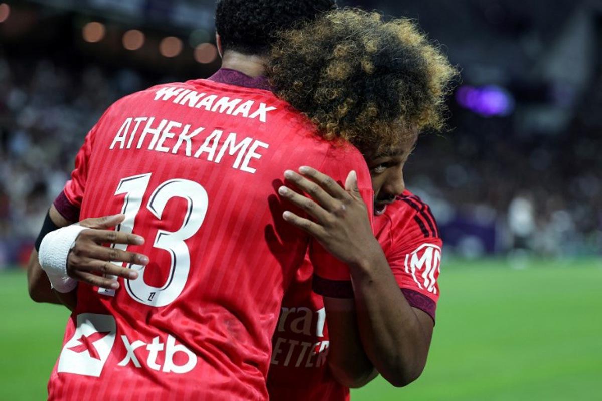 Lyon's Belgian forward #11 Malick Fofana (R) celebrates with Lyon's Swiss defender #13 Zachary Athekame (L) after scoring his team second goal during the French L1 football match between Toulouse Football Club (TFC) and Olympique Lyonnais (OL) at the Stadium in Toulouse, southwestern France, on August 22, 2026.  Valentine CHAPUIS / AFP