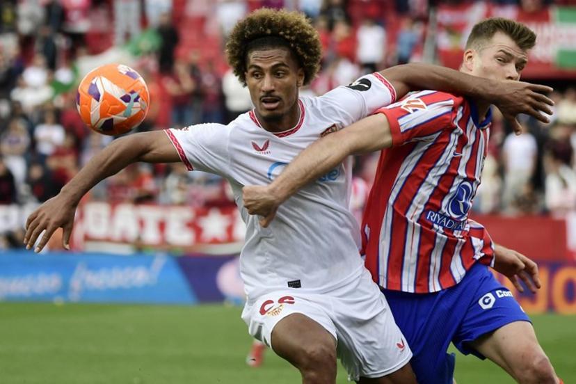 Sevilla's French defender #22 Loic Bade and Atletico Madrid's Norwegian forward #09 Alexander Sorloth fight for the ball during the Spanish league football match between Sevilla FC and Club Atletico de Madrid at the Ramon Sanchez Pizjuan stadium in Seville on April 6, 2025.  CRISTINA QUICLER / AFP