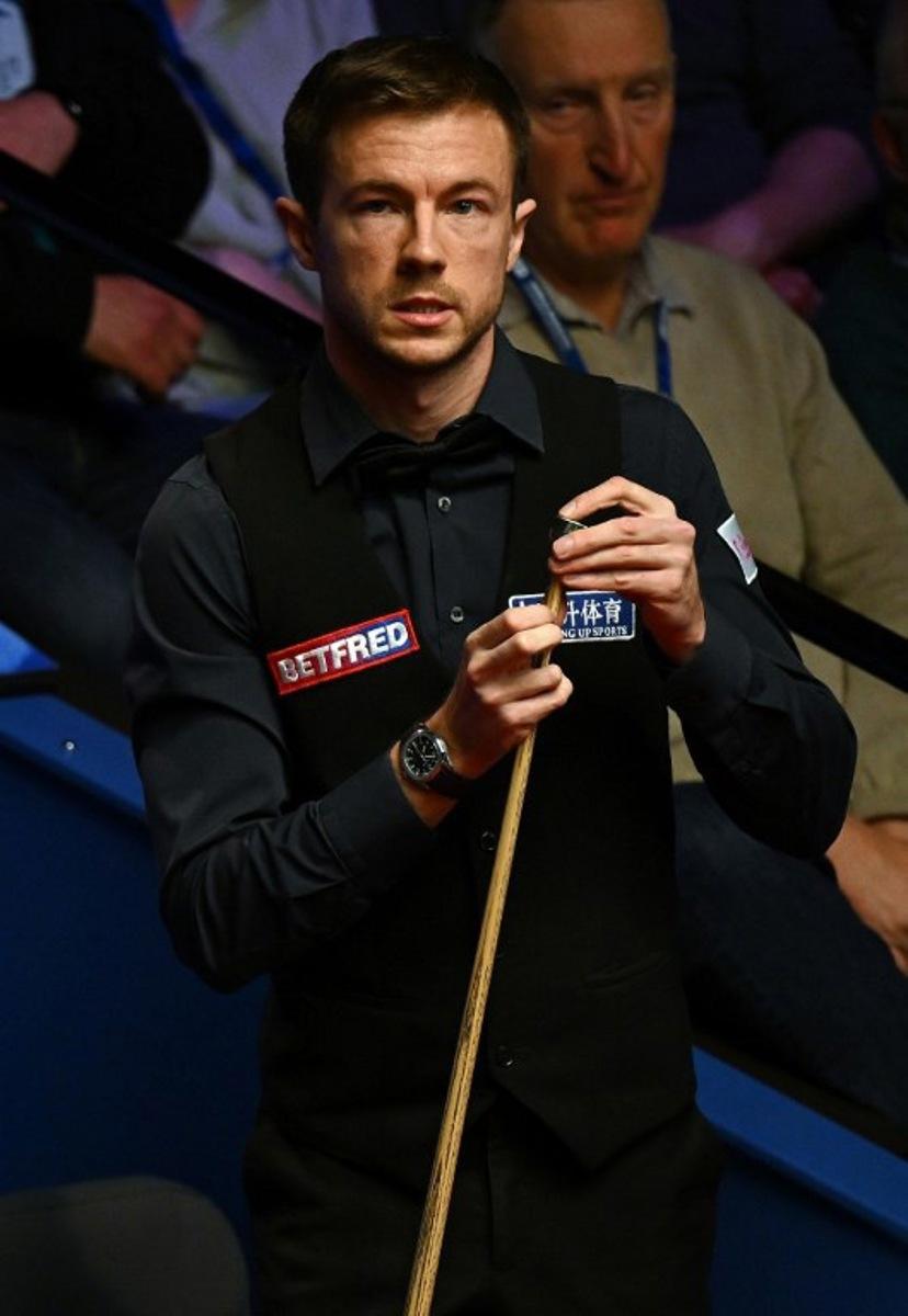 England's Jack Lisowski chalks his cue as he plays against Australia's Neil Robertson during their World Championship Snooker second round match at The Crucible in Sheffield, England on April 25, 2022.   Paul ELLIS / AFP