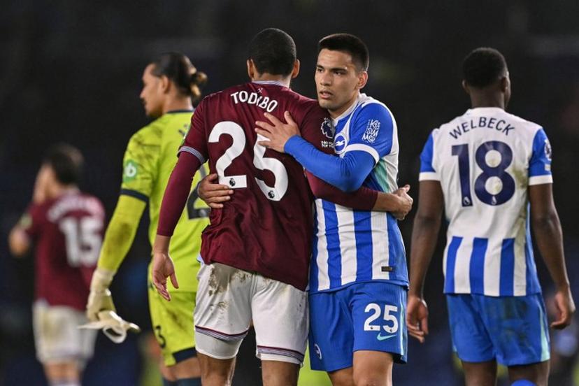 Brighton's Paraguayan midfielder #25 Diego Gomez (R) and West Ham United's French defender #25 Jean-Clair Todibo (L) embrace at the end of the English Premier League football match between Brighton and Hove Albion and West Ham United at the American Express Community Stadium in Brighton, southern England on December 7, 2025.  Glyn KIRK / AFP
