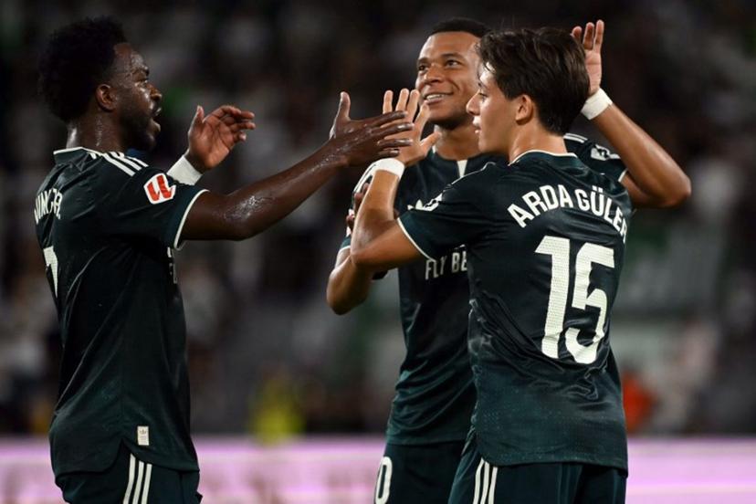 Real Madrid's Turkish midfielder #15 Arda Guler celebrates scoring the opening goal with Real Madrid's French forward #10 Kylian Mbappe next to Real Madrid's Brazilian forward #07 Vinicius Junior (L) during the Spanish league football match between Elche CF and Real Madrid CF at Martinez Valero Stadium in Elche on September 15, 2026.  JOSE JORDAN / AFP