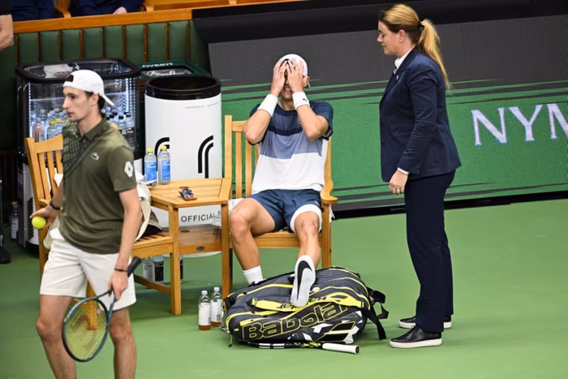 Denmark's Holger Rune (C) reacts after injurung his foot during the semi-final of the BNP Paribas Nordic Open tennis tournament against France's Ugo Humbert (L) at the Royal Swedish Tennis Hall in Stockholm, Sweden, on October 18, 2025. Anders WIKLUND / TT NEWS AGENCY / AFP