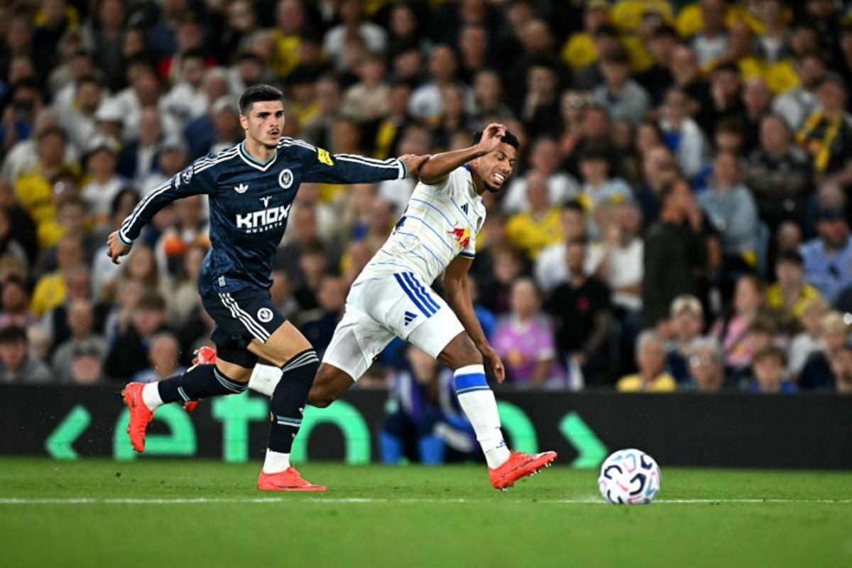 Newcastle United's Belgian striker #20 Matias Fernandez-Pardo battles for the ball with Leeds United's English defender #24 James Justin during the English Premier League football match between Leeds United and Newcastle United at Elland Road in Leeds, northern England on September 14, 2026. Paul ELLIS / AFP