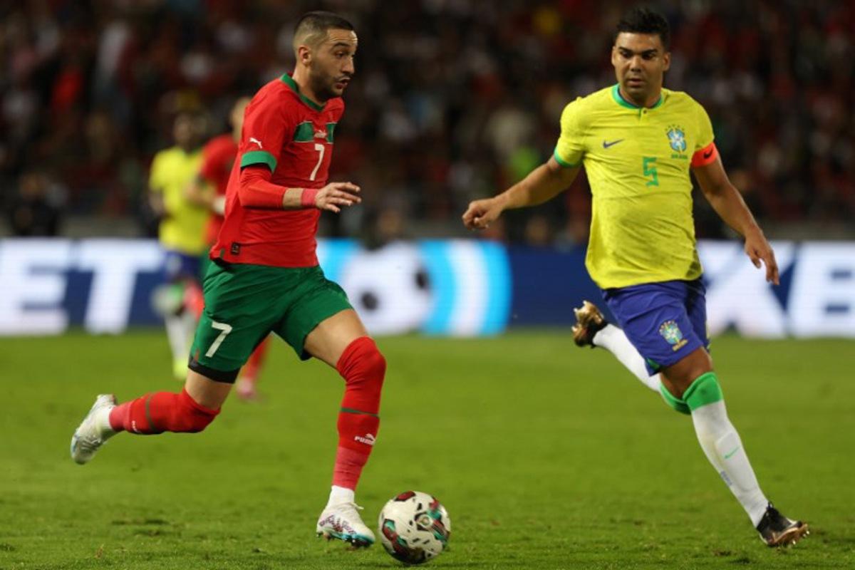 Morocco's midfielder Hakim Ziyech is marked by Brazil's midfielder Casemiro (R) during a friendly football match between Morocco and Brazil at the Ibn Batouta Stadium in Tangier on March 26, 2023. Fadel Senna / AFP
