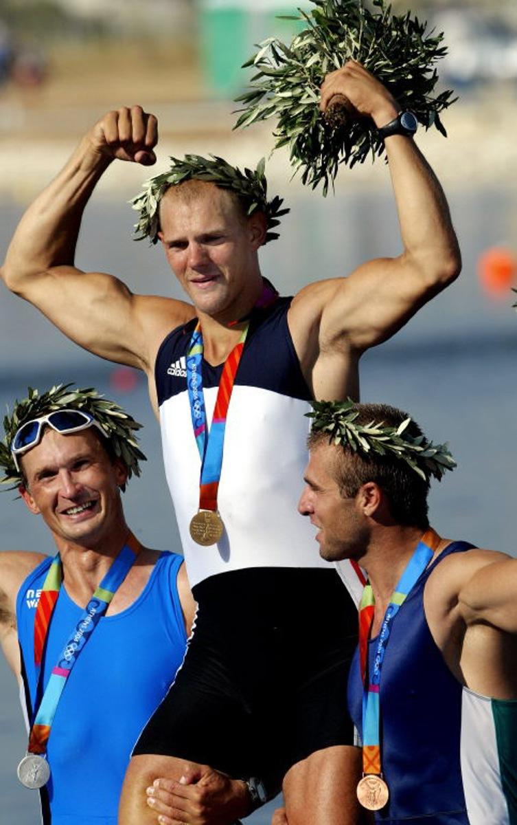 Silver medal from Estonia Jueri Jaanson (L) and bronze medalist from Bulgaria Ivo Yanakiev (R) lift gold medalist Norwegian Olaf Tufte during the medal ceremony for the Men's Single Sculls final for the Athens 2004 Olympic Games at the Schinias Rowing and Canoeing Center, outside Athens, 21 August 2004. AFP PHOTO / MLADEN ANTONOV MLADEN ANTONOV / AFP