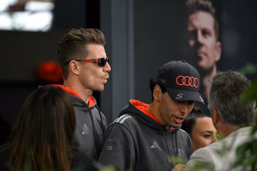 Audi's German driver Nico Hulkenberg (L) and Audi's Brazilian driver Gabriel Bortoleto (C) walk through the paddock ahead of the third practice session of the Formula One Australian Grand Prix at the Albert Park Circuit in Melbourne on March 7, 2026. Paul Crock / AFP