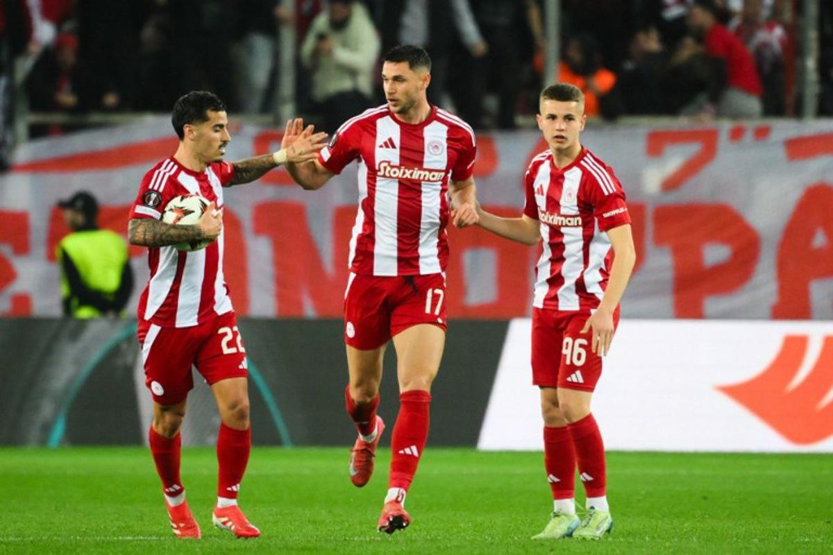 Olympiakos' Ukrainian forward #17 Roman Yaremchuk (C) celebrates with teammates Olympiakos' Portuguese mifielder #22 Chiquinho (L) and Olympiakos' Greek midfielder #96 Christos Mouzakitis (R) after scoring the 2-1 goal during the second leg last 16 UEFA Europa League football match between Olympiacos (GRE) and Bodo/Glimt (NOR) at Stadio Georgios Karaiskakis in Piraeus on March 13, 2025. Angelos TZORTZINIS / AFP