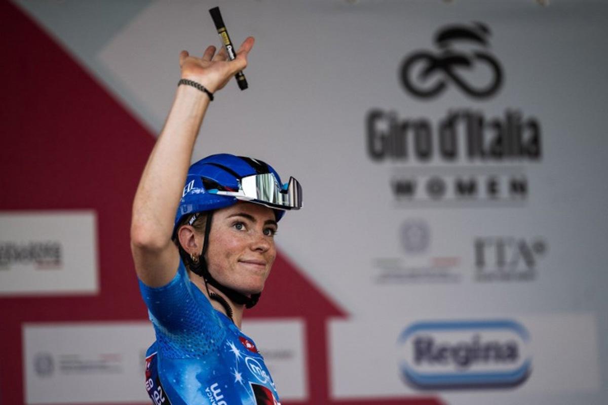 FDJ Suez's Dutch cyclist Demi Vollering, wearing the best climber's blue jersey (Maglia Azzurra), waves during the pre-stage presentation ahead of the 9th stage of the Giro d'Italia Women 2026 between Saluzzo and Saluzzo in Saluzzo on June 7, 2026. MARCO BERTORELLO / AFP