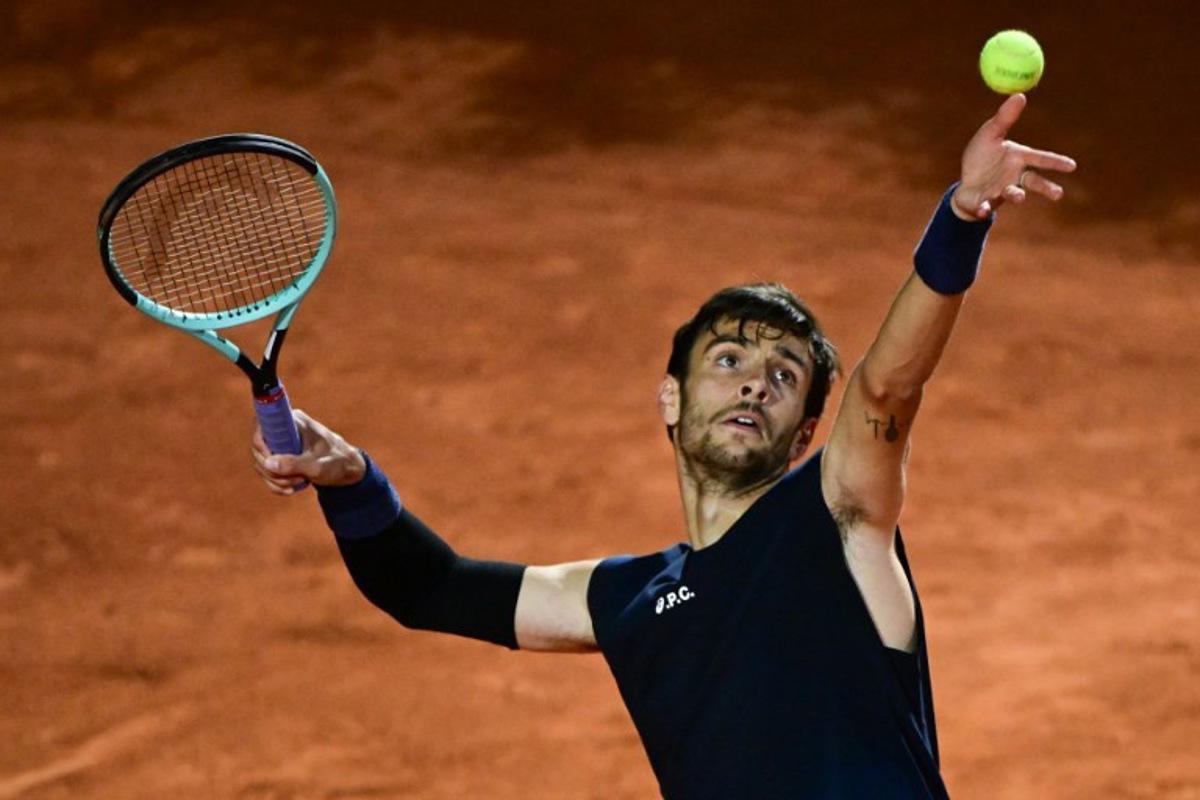 Italy's Lorenzo Musetti serves to Germany's Alexander Zverev during the men's singles quarter-final match at the ATP Rome Open tennis tournament at Foro Italico in Rome on May 14, 2025. PIERO CRUCIATTI / AFP