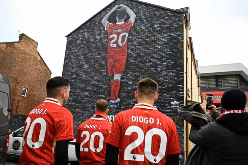 Fans visit a mural created by artist Murwalls, dedicated to Liverpool's late Portugese footballer Diogo Jota who died in a car crash in July, ahead of the English Premier League football match between Liverpool and Wolverhampton Wanderers at Anfield in Liverpool, north west England on December 27, 2025. Father of three Jota, who married his long-term partner Rute Cardoso 11 days before the accident, died alongside his brother after a Lamborghini they were travelling in came off the road and burst into flames in northern Spain in July. Oli SCARFF / AFP
