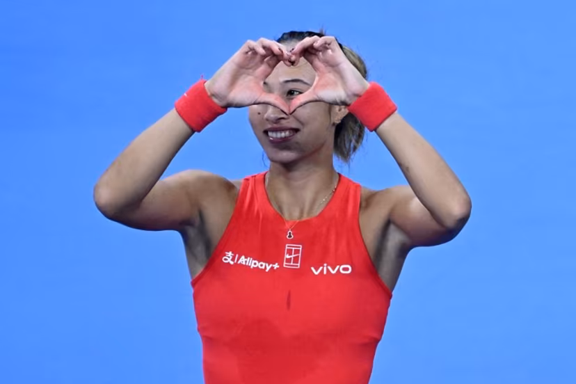 China's Zheng Qinwen make a heart sign to spectators for her birthday wishes as she celebrates beating Armenia's Alina Charaeva in their women's singles match at the China Open tennis tournament in Beijing on October 7, 2026. ADEK BERRY / AFP