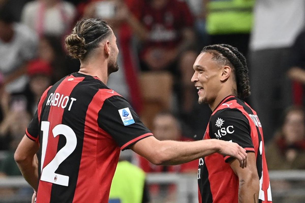 Milan's Belgian midfielder #22 Diego Moreira (R) celebrates with Milan's French midfielder #12 Adrien Rabiot (C) after scoring his team's third goal during the Italian Serie A football match between AC Milan and Lecce at the San Siro stadium in Milan, on September 20, 2026. Isabella BONOTTO / AFP
