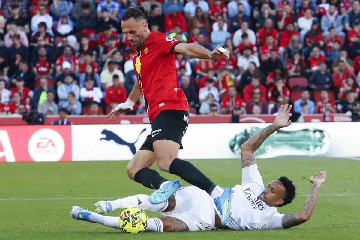Real Mallorca's Kosovar forward #7 Vedat Muriqi fights for the ball with Real Madrid's Brazilian defender #3 Eder Militao during the Spanish league football match between RCD Mallorca and Real Madrid CF at Mallorca Son Moix Stadium in Palma de Mallorca on April 4, 2026. JAIME REINA / AFP