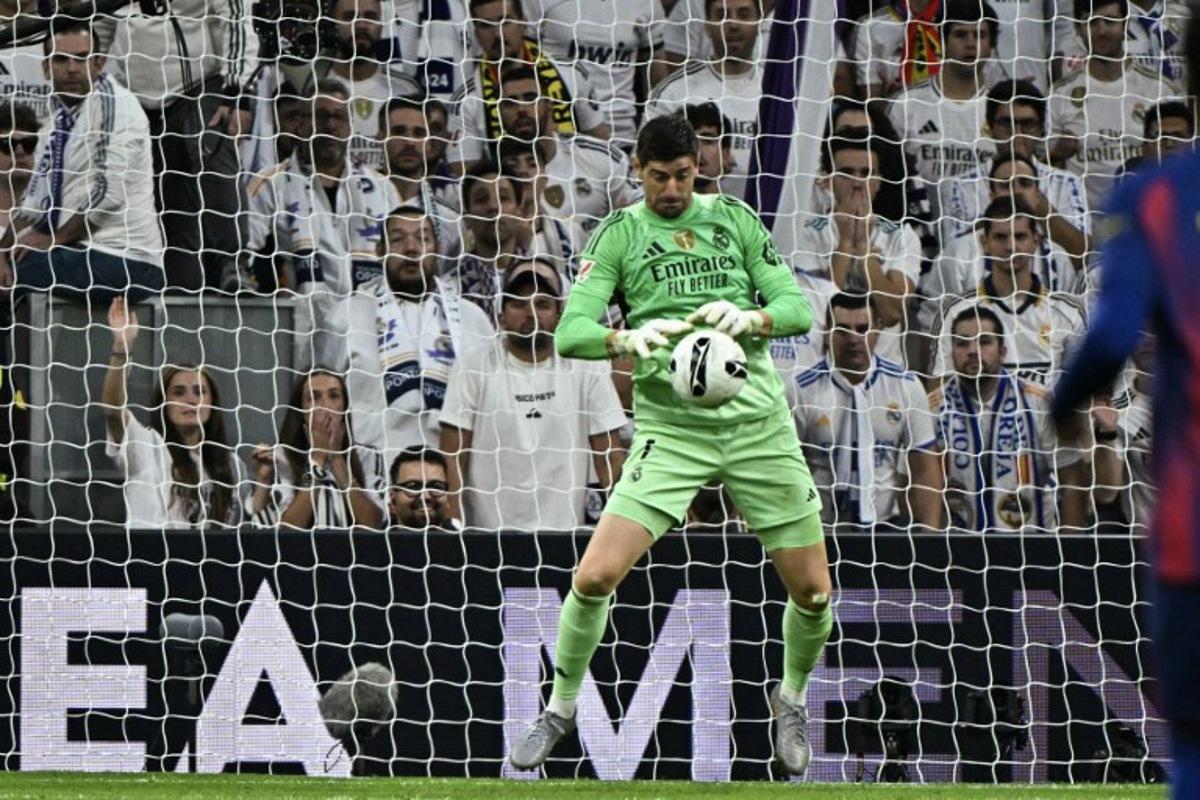 Real Madrid's Belgian goalkeeper #01 Thibaut Courtois stops a shot on goal during the Spanish league football match between Real Madrid CF and FC Barcelona at the Santiago Bernabeu stadium in Madrid on October 26 , 2025. JAVIER SORIANO / AFP