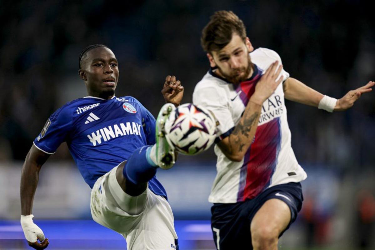 Strasbourg's Swedish defender #16 Genesis Antwi (L) kicks the ball past Paris Saint-Germain's Georgian forward #07 Khvicha Kvaratskhelia during the French L1 football match between RC Strasbourg Alsace and Paris Saint-Germain (PSG) at the Stade de la Meinau in Strasbourg, eastern France, on October 17, 2026. ROMEO BOETZLE / AFP