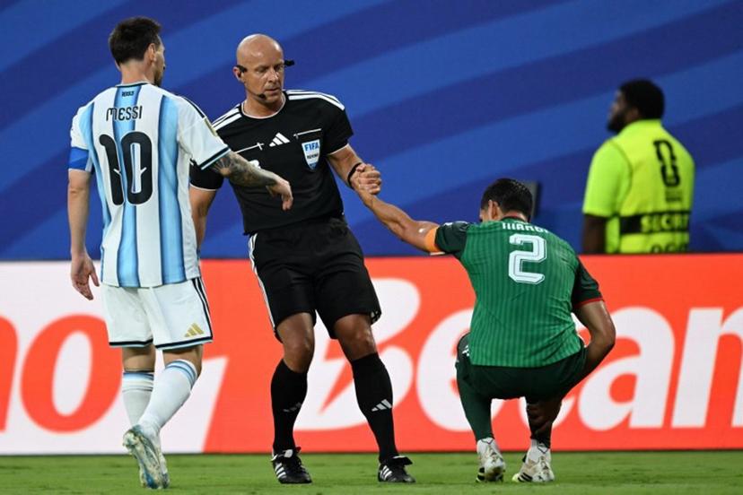 Polish referee Szymon Marciniak lifts Algeria's defender #02 Aissa Mandi as he reacts in pain next to Argentina's forward #10 Lionel Messi during the 2026 World Cup Group J football match between Argentina and Algeria at the Kansas City Stadium in Kansas City on June 16, 2026. ROBERTO SCHMIDT / AFP