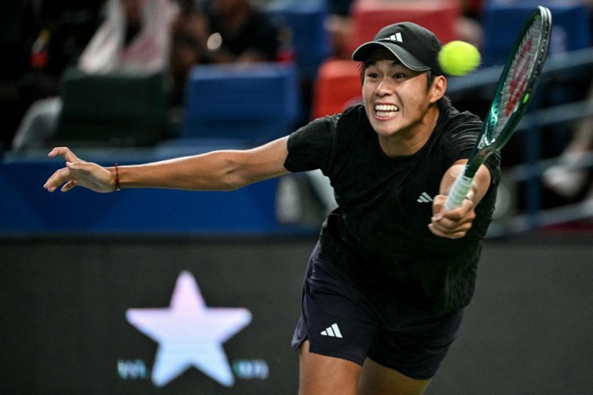 United States's Learner Tien hits a return to Russia's Daniil Medvedev during their men's singles match at the Shanghai Masters tennis tournament in Shanghai on October 8, 2025. HECTOR RETAMAL / AFP