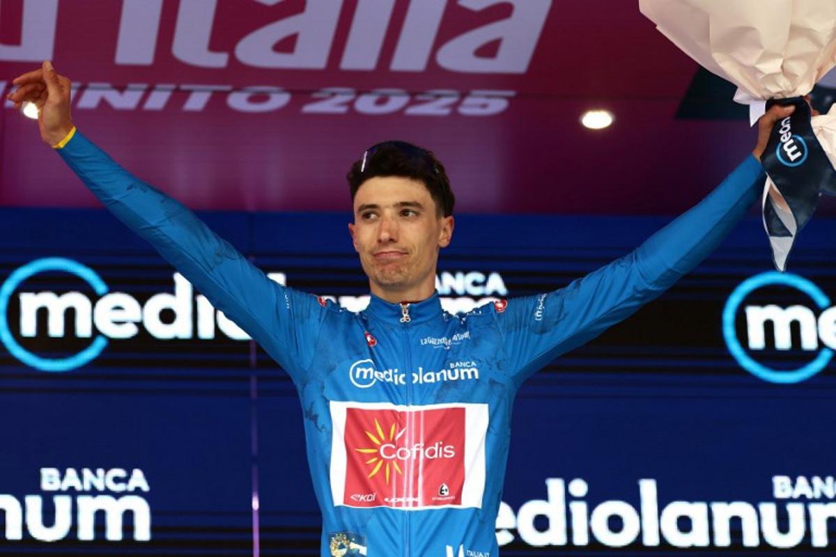 Cofidis' Belgian rider Sylvain Moniquet wears the best climber's blue jersey on the podium after the first stage of the 108th Giro d'Italia cycling race, 160km from Durres to Tirana in Albania, on May 9, 2025. Luca Bettini / AFP