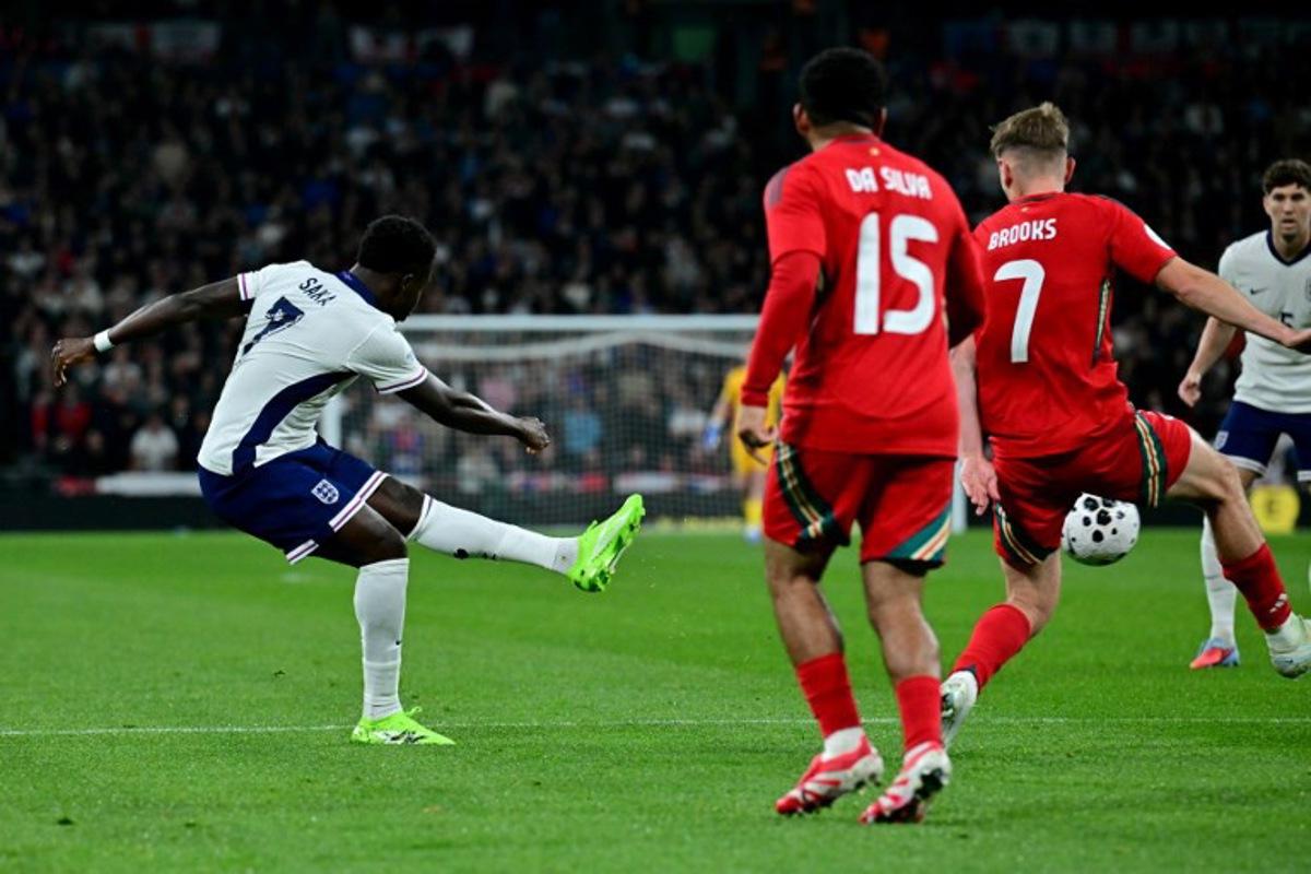 England's midfielder Bukayo Saka scores the team's third goal during the friendly football match between England and Wales at Wembley Stadium in London on October 9, 2025. Ben STANSALL / AFP