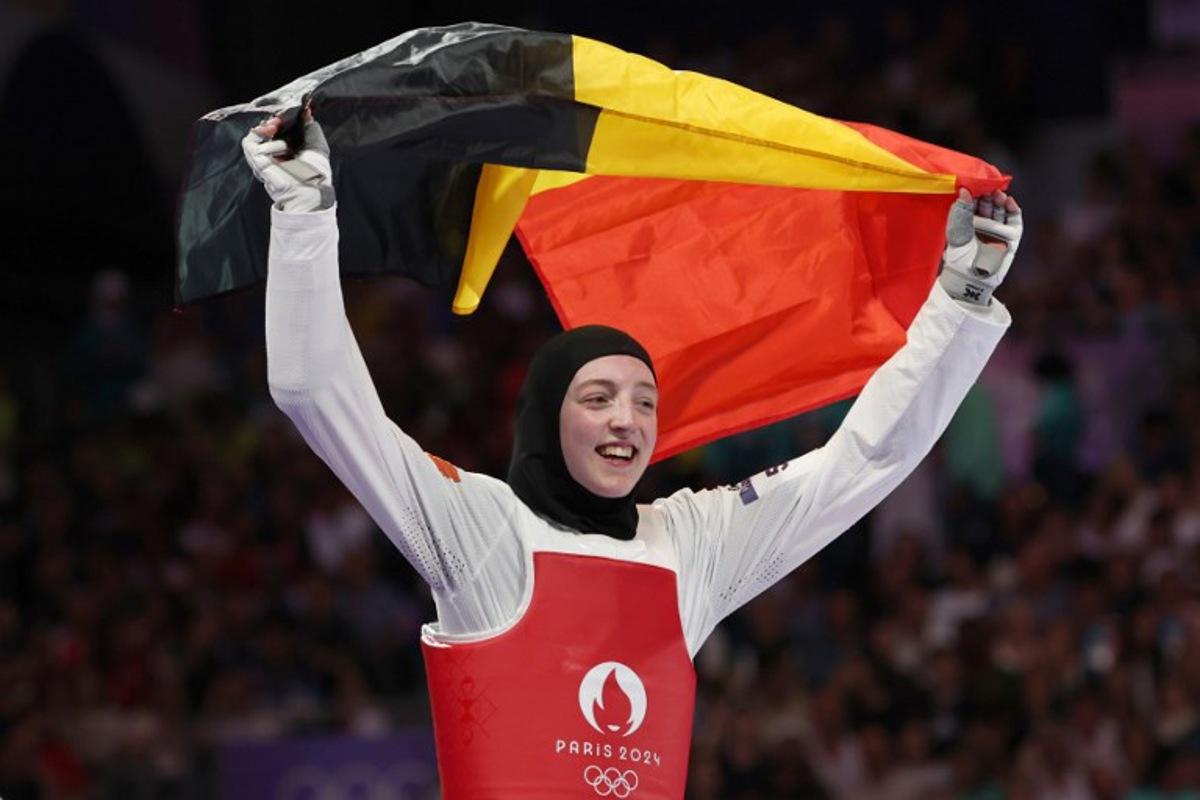 Belgium's Sarah Chaari celebrates with her country's flag after winning in the taekwondo women's -67kg bronze medal bout of the Paris 2024 Olympic Games at the Grand Palais in Paris on August 9, 2024. David GRAY / AFP