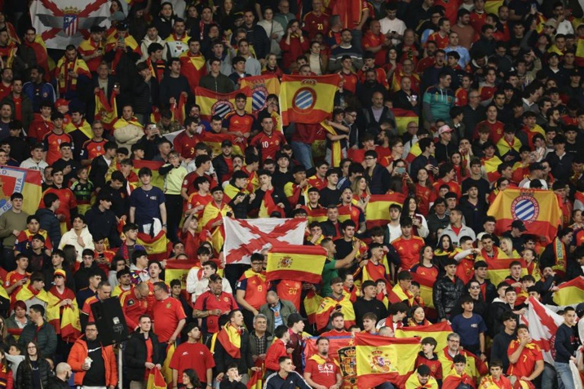 Spain supporters hold up flags during the international friendly football match between Spain and Egypt at RCDE Stadium in Cornella de Llobregat, near Barcelona, on March 31, 2026. Police in Spain said on Wednesday that they were investigating "Islamophobic and xenophobic" chants heard during the Spain-Egypt international football match in Barcelona. Egypt's national anthem was jeered ahead of the 0-0 draw in Barcelona on Tuesday in a pre-World Cup friendly and authorities at the RCDE Stadium appealed to fans more than once over the public announcement system to refrain from making offensive comments. Lluis GENE / AFP