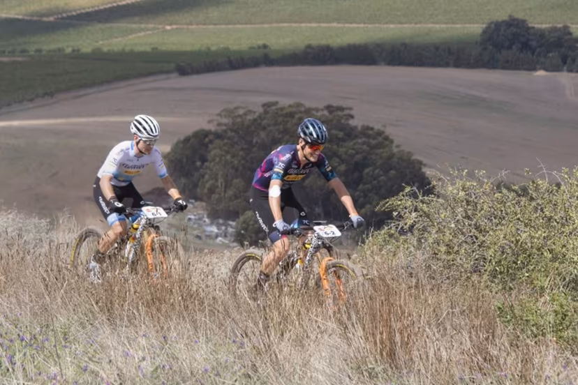 Fabian Rabensteiner (R) and teammate, Wout Alleman, ride during the prologue stage of the 2023 Cape Epic mountain bike stage race, in Durbanville, near Cape Town on March 19, 2023. The Cape Epic, in which two riders race as a team, is widely known as one of the foremost mountain bike stage race in the world, with the riders from all around the world covering a distance of approximately 700 kilometres, and gaining over 16000m in height, over eight days of racing. RODGER BOSCH / AFP